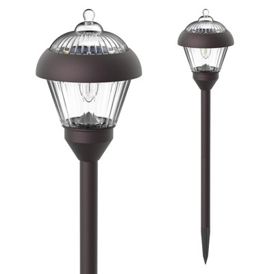 Decorative bronze solar path light casting shadow patterns